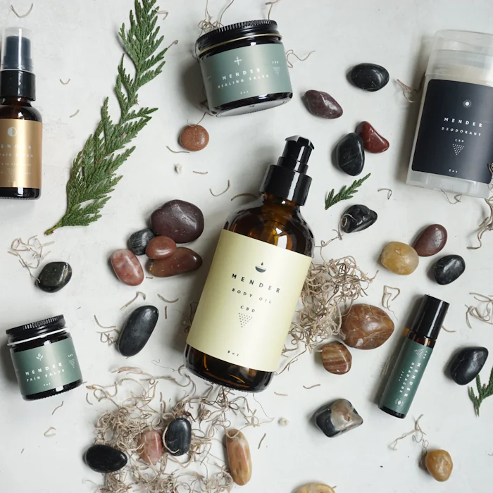 Bottles of essential oils with smooth stones and fresh herbs