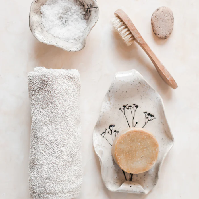Bath salts, a natural bristle brush and a rolled towel
